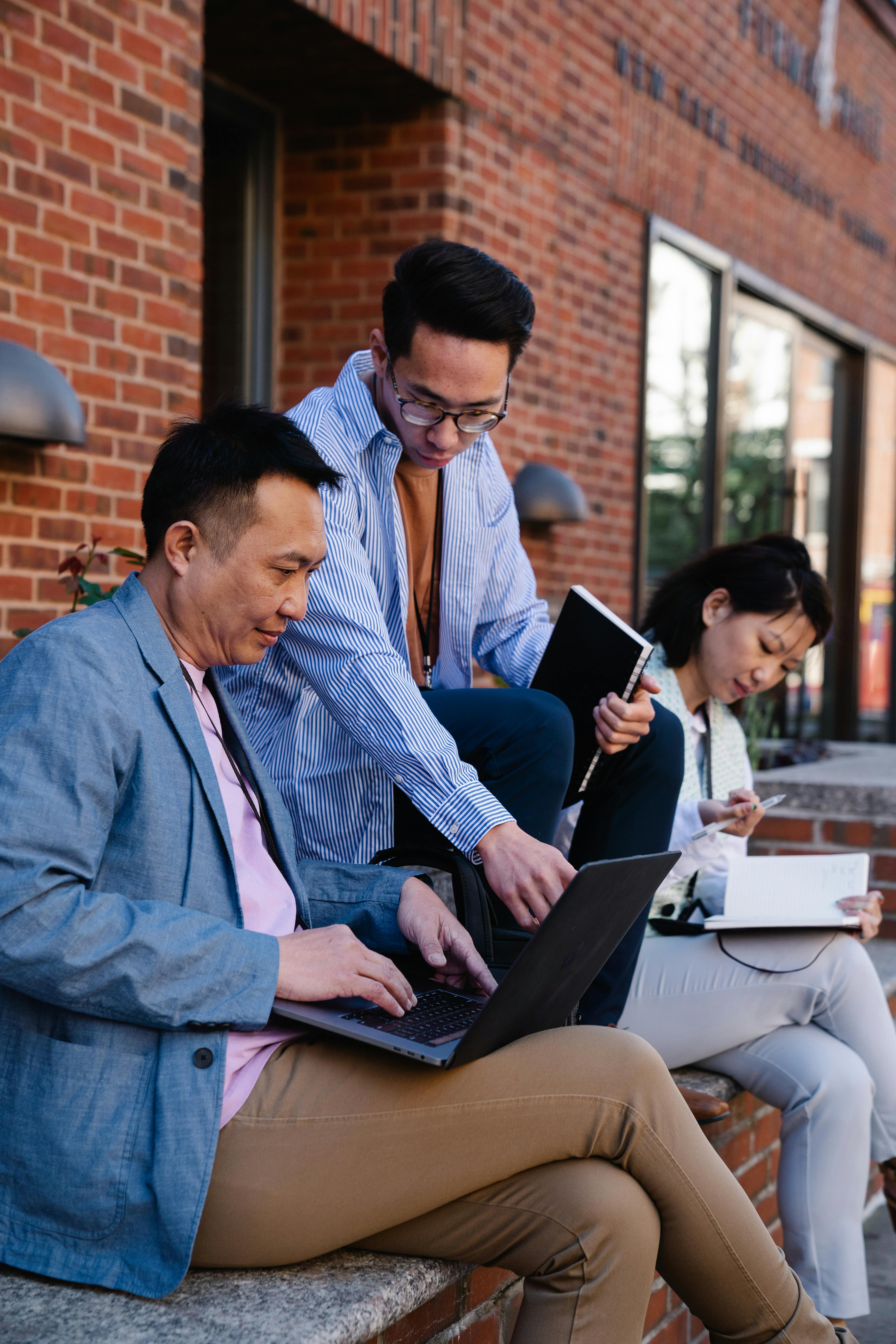 Professionals in discussion at a conference or workshop table with documents. Photo: Felicity Tai / Pexels.
