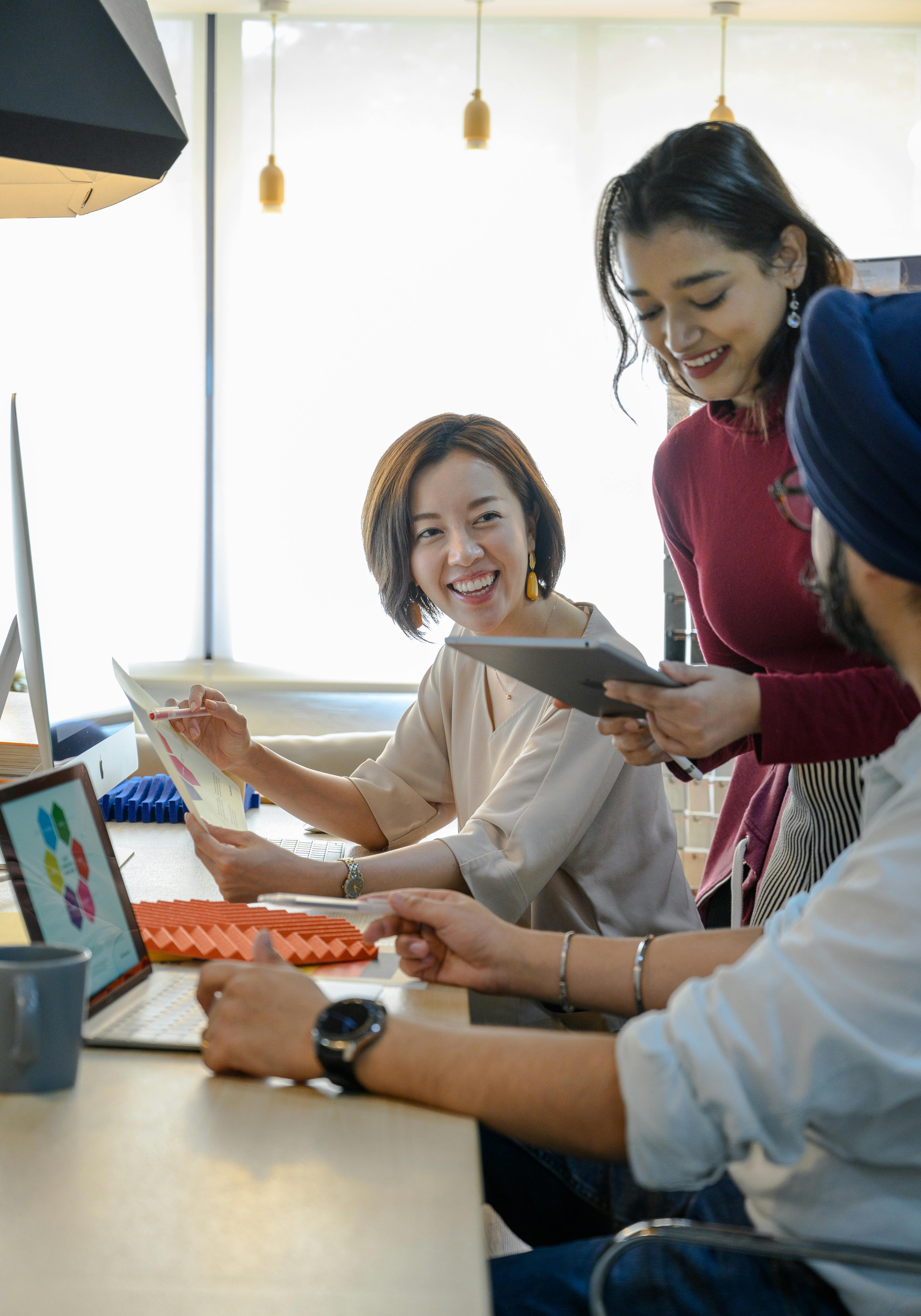 Team working together with laptops and documents at a shared table. Photo: Ketut Subiyanto / Pexels.