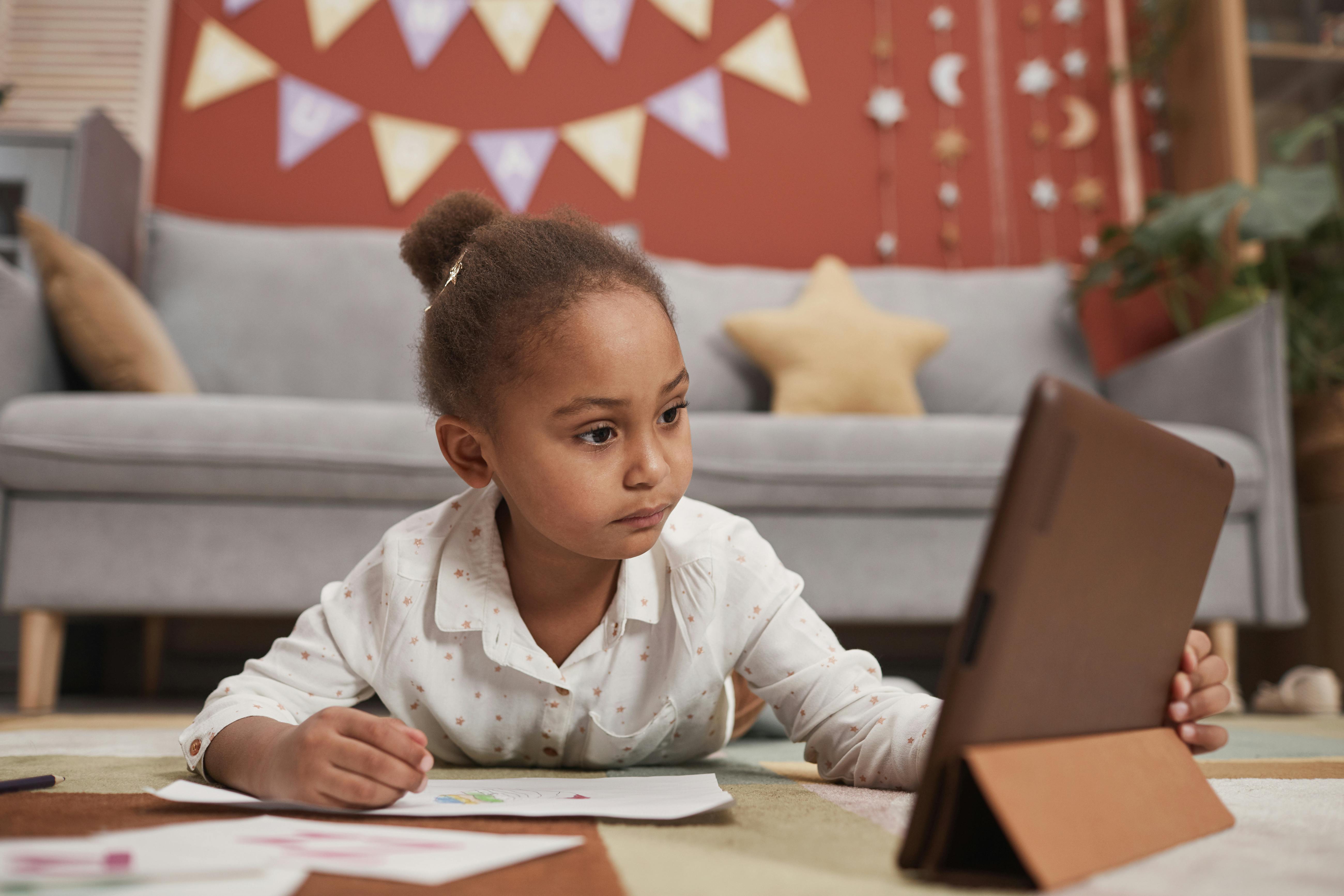 Young learner writing and using a tablet for reading and study at home. Photo: Werner Pfennig / Pexels.