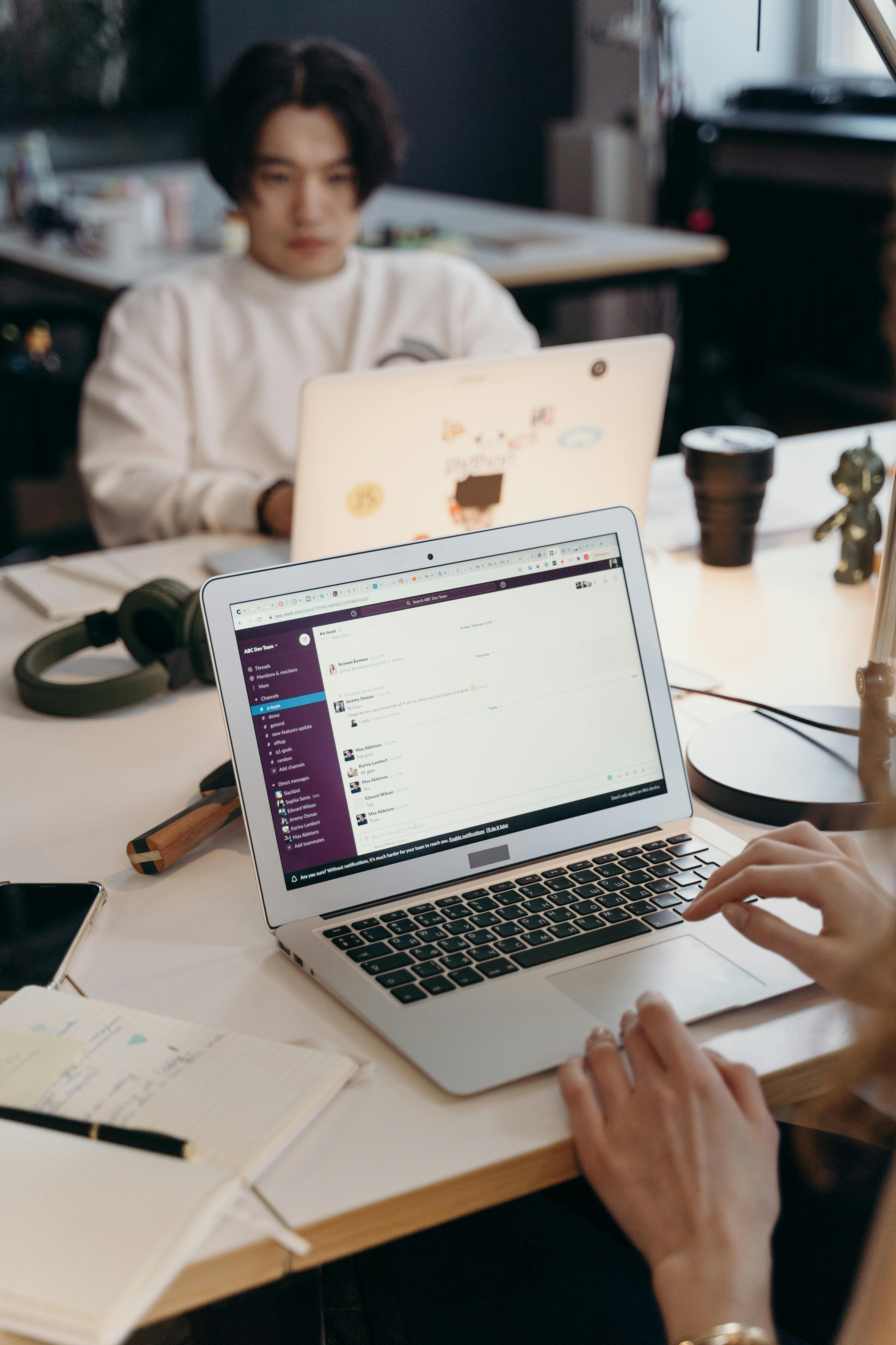 Students collaborating at laptops with notebooks in a bright workspace. Photo: cottonbro / Pexels.