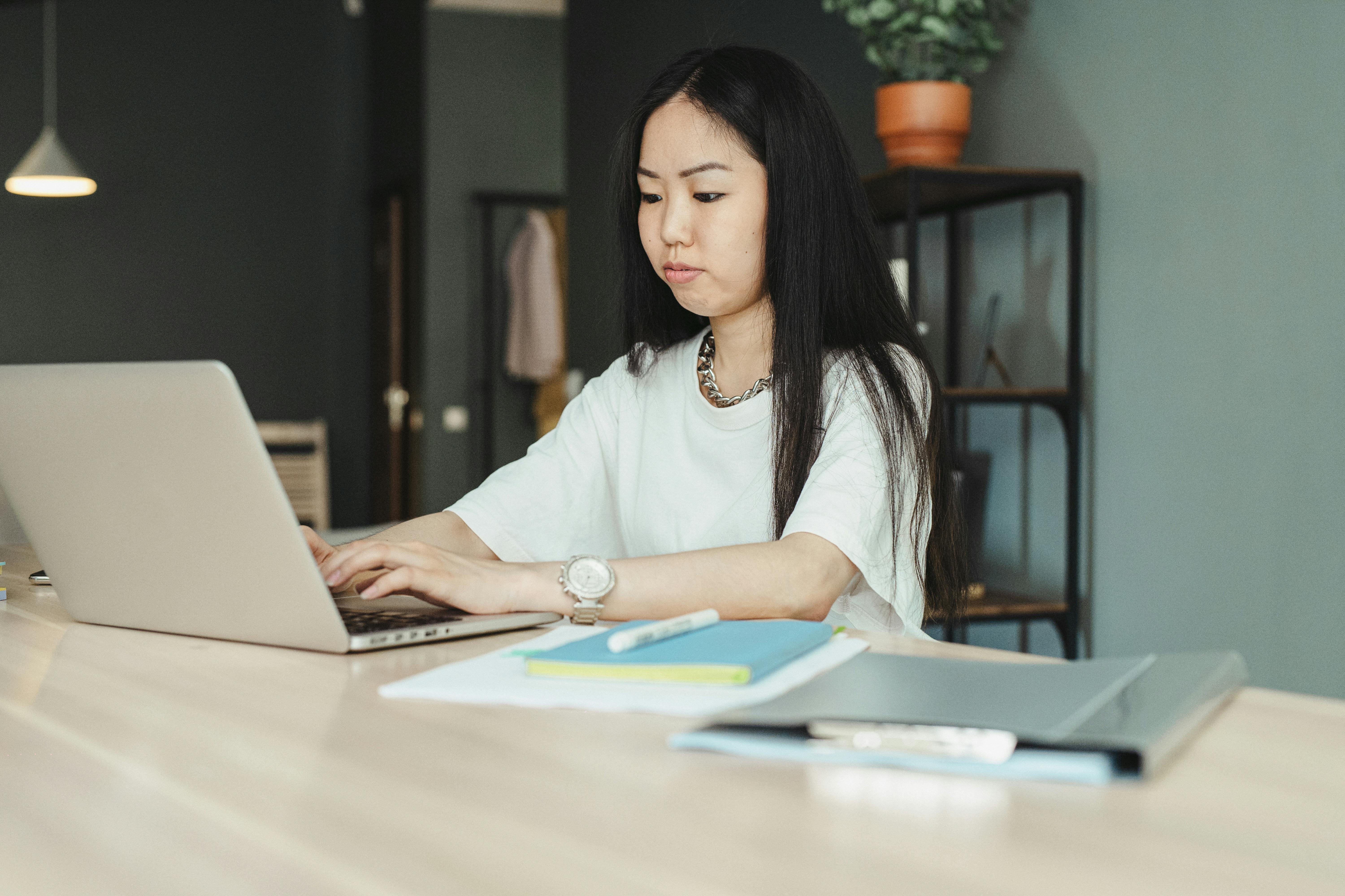 Student typing on a laptop with notebooks and study materials on the desk. Photo: SHVETS production / Pexels.